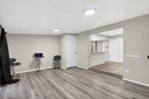 Workout area with light wood-type flooring and baseboards