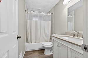 Bathroom with vanity, shower / bathtub combination with curtain, and light wood-style flooring