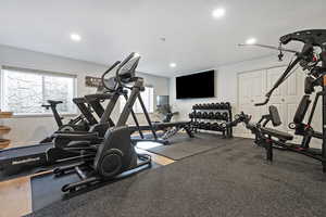Exercise room with healthy amount of natural light, rubber floors, and recessed lighting