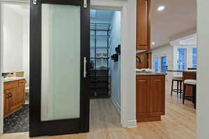 Hall with recessed lighting, light wood finished floors, and a barn door