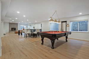 Rec room with pool table, light wood-style floors, a fireplace, and recessed lighting