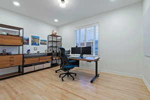 Office space featuring light wood-style flooring and recessed lighting