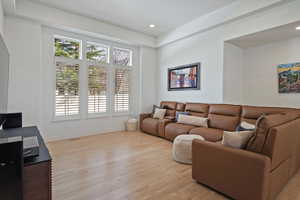 Living room with light wood-type flooring and recessed lighting