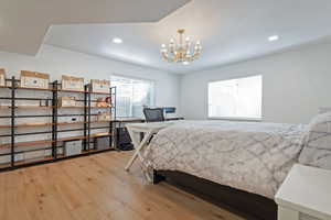 Bedroom featuring light wood finished floors and suspended lighting