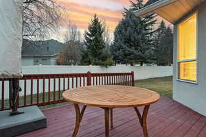 Deck at dusk with a fenced backyard
