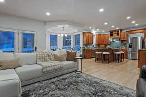 Living room with light wood-style flooring and hanging lights