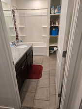 Bathroom featuring vanity, light tile patterned floors, and shower / washtub combination
