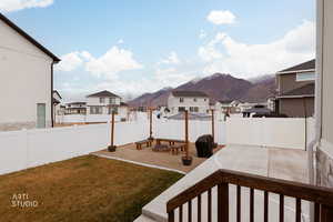 Fenced backyard with a residential view, a mountain view, and a patio area