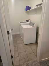Laundry area featuring light tile patterned floors and washing machine and clothes dryer