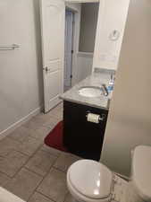Half bathroom featuring vanity and light tile patterned floors
