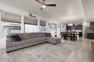 Living area featuring ceiling fan, a chandelier, healthy amount of natural light, and light wood-style flooring