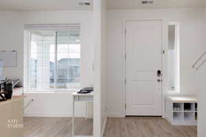 Foyer entrance with light wood finished floors