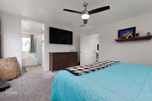 Bedroom featuring a ceiling fan, carpet flooring, and connected bathroom