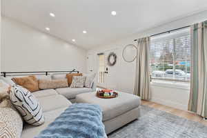 Living room with wood finished floors, recessed lighting, and vaulted ceiling