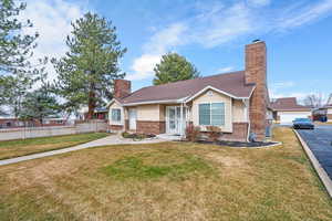 Ranch-style house featuring a chimney and brick siding