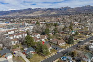 Aerial view of property and surrounding area featuring mountains and nearby suburban area