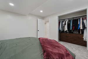 Bedroom featuring light colored carpet, a closet, and recessed lighting