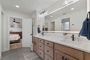 Full bathroom featuring double vanity, light tile patterned floors, ensuite bath, recessed lighting, and ceiling fan
