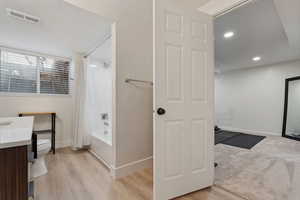 Full bathroom featuring vanity, shower / tub combo with curtain, light wood-style floors, and recessed lighting