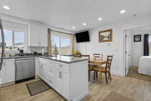 Kitchen featuring dark stone countertops, white cabinets, recessed lighting, stainless steel appliances, and light wood-style flooring