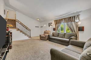 Living area featuring lofted ceiling and carpet