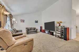 Living room featuring light colored carpet and vaulted ceiling