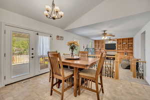 Dining area featuring lofted ceiling, built in features, suspended lighting, ceiling fan, and light tile patterned floors
