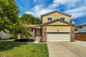 Traditional-style home with brick siding, concrete driveway, and stucco siding