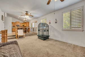 Living area featuring ceiling fan, light colored carpet, vaulted ceiling, and recessed lighting
