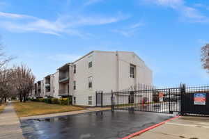 View of apartment building / complex featuring uncovered parking
