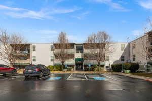View of apartment building / complex with uncovered parking