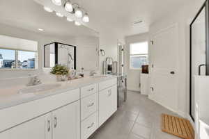 Spacious primary en-suite bathroom featuring a double quartz vanity, oversized soaking tub, separate shower with cultured marble surround, and a private toilet room.