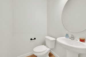 Convenient main-level half bathroom designed with clean finishes and cohesive black hardware details.