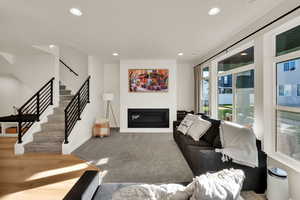 Inviting living space centered around a long gas fireplace, enhanced by 8-foot doors and upgraded black hardware throughout.