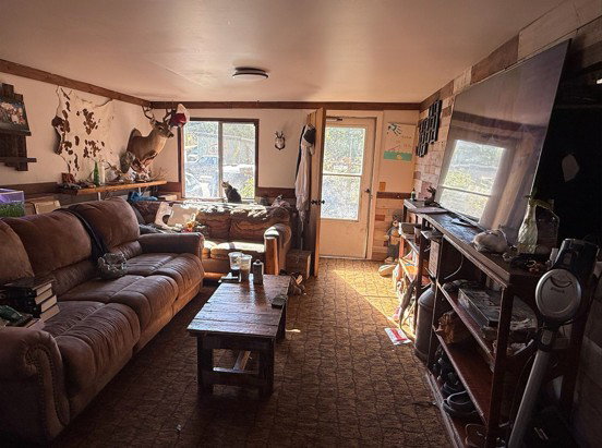 Living area with wainscoting and dark colored carpet