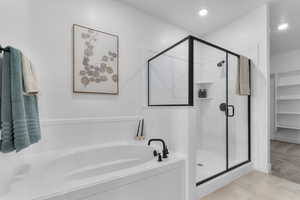 Bathroom with a shower stall, a garden tub, a walk in closet, recessed lighting, and light colored carpet