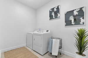 Laundry area with baseboards and washing machine and clothes dryer