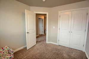 Unfurnished bedroom with carpet and a closet