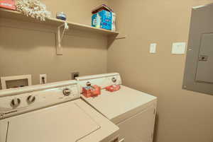 Laundry room with electric panel and washer and dryer