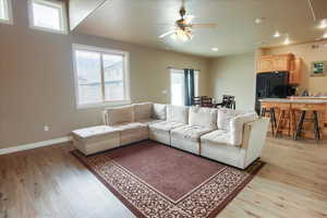 Living area with a ceiling fan, light wood-style floors, and recessed lighting