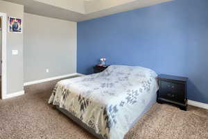 Carpeted bedroom featuring baseboards and ceiling fan