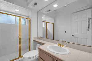 Full bath with a stall shower, vanity, and recessed lighting