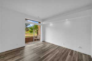 Spare room featuring baseboards and wood finished floors