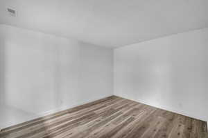 Unfurnished room featuring light wood finished floors and a textured ceiling