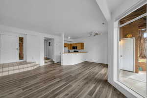 Unfurnished living room featuring light wood-style flooring and a ceiling fan
