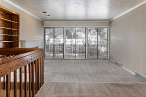 Empty room with carpet and a textured ceiling