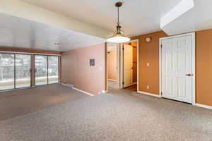 Unfurnished dining area featuring a textured ceiling and carpet floors