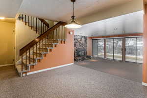 Unfurnished living room featuring a textured ceiling and carpet