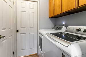 Laundry area with cabinet space and washing machine and clothes dryer
