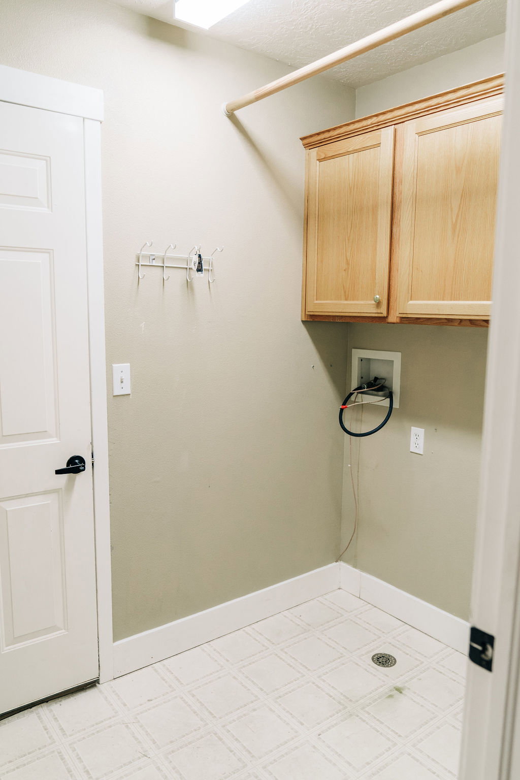Laundry room featuring light flooring, hookup for a washing machine, and cabinet space